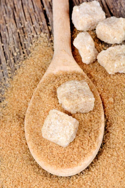 Beige sugar in a wooden spoon on table — Free Stock Photo