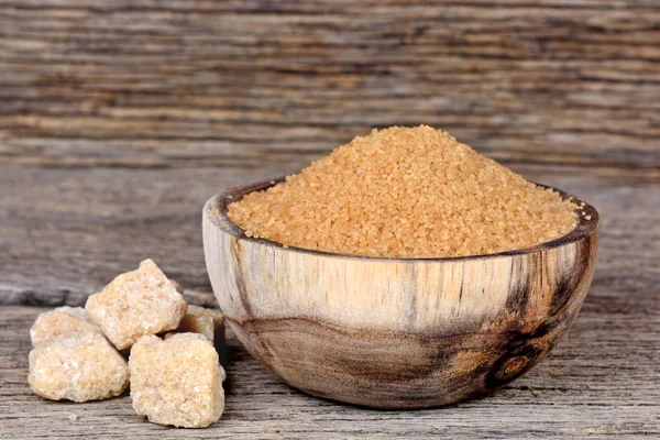 Tablo üzerinde ham şeker ile bir kase kahverengi şeker