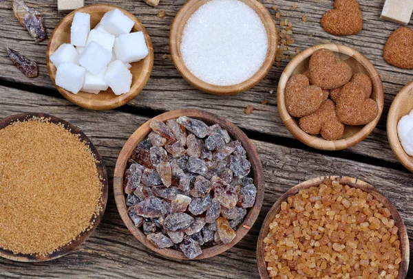 Verschillende soorten suiker in een kommen op houten tafel — Stockfoto