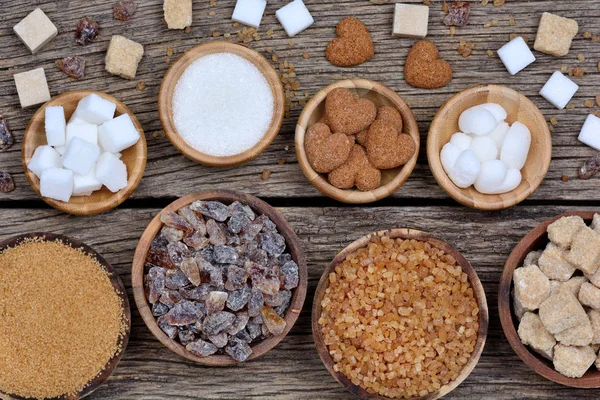 Různé druhy cukru v miskách na stole — Stock fotografie