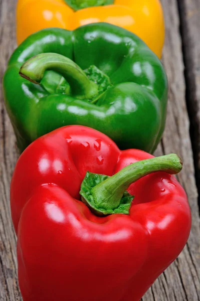 Pimenta colorida no fundo de madeira — Fotografia de Stock