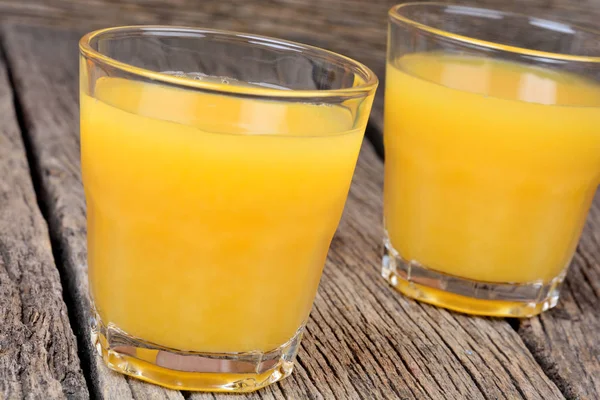 Sumo de laranja em uns copos no fundo de madeira — Fotografia de Stock