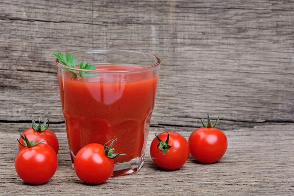 Copo de suco de tomate fresco no fundo de madeira — Fotografia de Stock