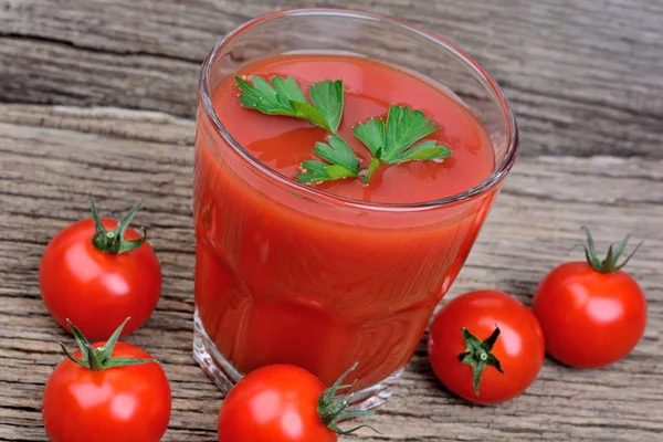 Ahşap arka plan üzerine bir bardak domates suyu — Stok fotoğraf