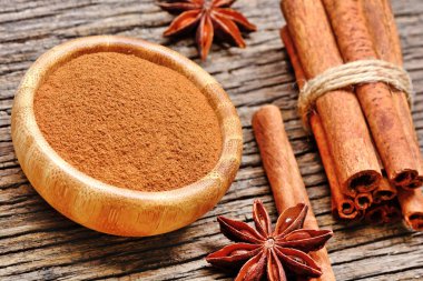 Sopa ve anason yıldızlı rustik masada bir kase toz tarçın