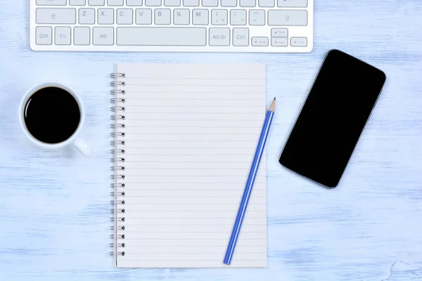 Notizblock mit Telefon, Tastaturcomputer und Kaffee auf dem Schreibtisch — Stockfoto