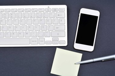 Ofis Masası olan klavye bilgisayar ile telefon ve notlar