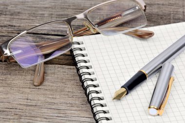 Defter ile dolma kalem ve tablo gözlük