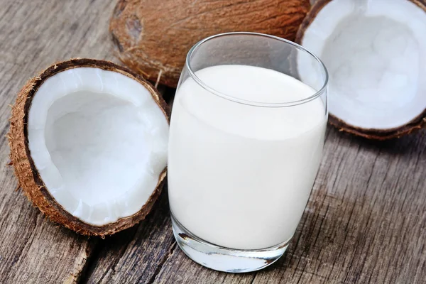 Leite de coco em um copo na mesa rústica — Fotografia de Stock