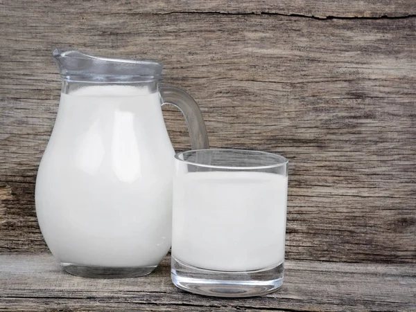 Milk in glassware on rustic table — Stock Photo, Image
