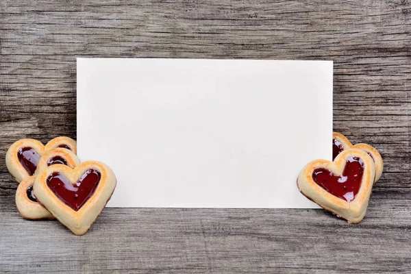 Empty paper with heart cookies on table