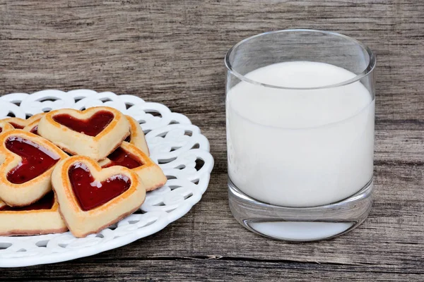 Heart cookies in a plate with milk of glass on table