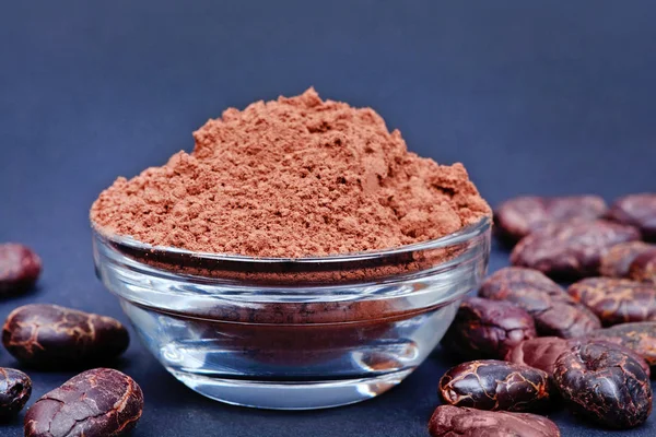 Cacao powder in a bowl on blue background — Stock Photo, Image
