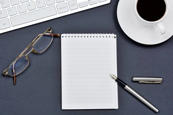 Arbeitsplatz mit einer Tasse Kaffee, Notizblock und Tastaturcomputer — Stockfoto