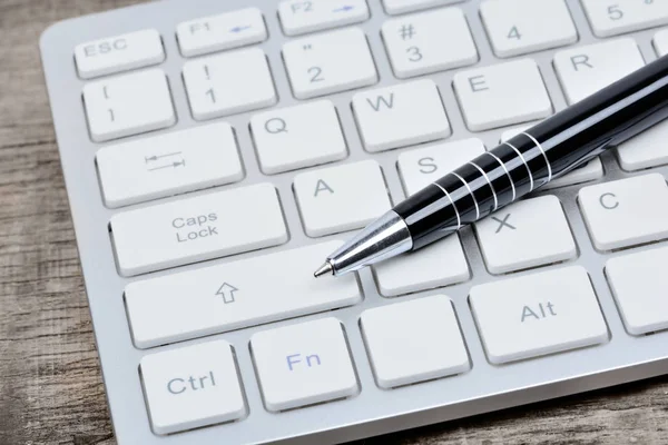 テーブルの上にペンとキーボード コンピューター — ストック写真