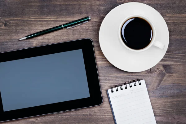 Digitala tablett, kaffe, anteckningsblock och penna från ovan — Stockfoto