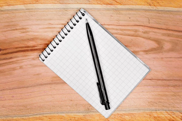 Bloco de notas em branco com caneta na mesa — Fotografia de Stock