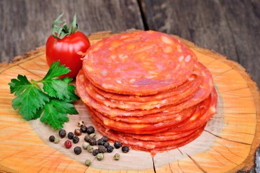 Chorizo salam maydanoz ve kiraz domates ahşap kesme tahtası üzerinde dilimlenmiş
