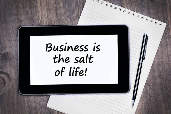 Business is the salt of life! Text on tablet device on a wooden table — Stock Photo, Image