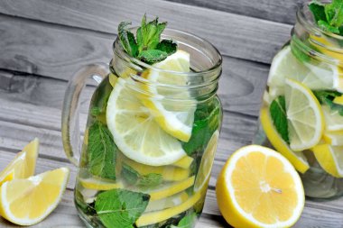 Limon ve nane bir kavanoz ahşap masa üzerinde su Detoks