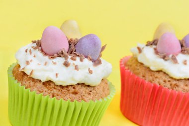Sarı zemin üzerine çikolata yumurta ile cupcakes
