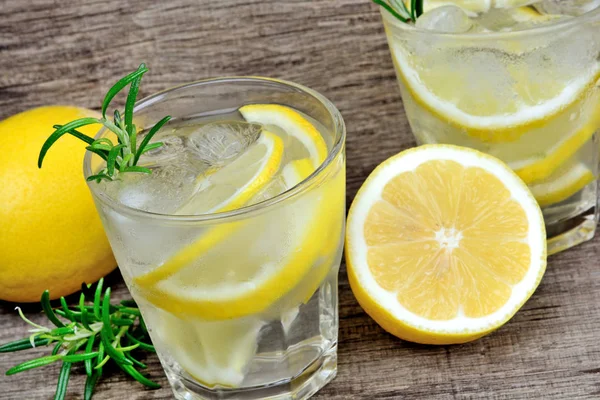 Entgiftungswasser mit in Scheiben geschnittenen Zitronen und Rosmarin im Glas. Erfrischendes kaltes Sommergetränk — Stockfoto