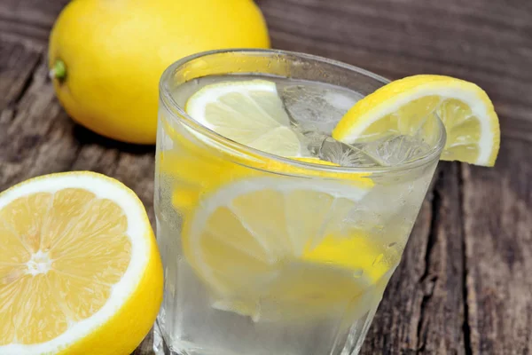 Glas Frischwasser mit Zitrone auf dem Tisch — Stockfoto