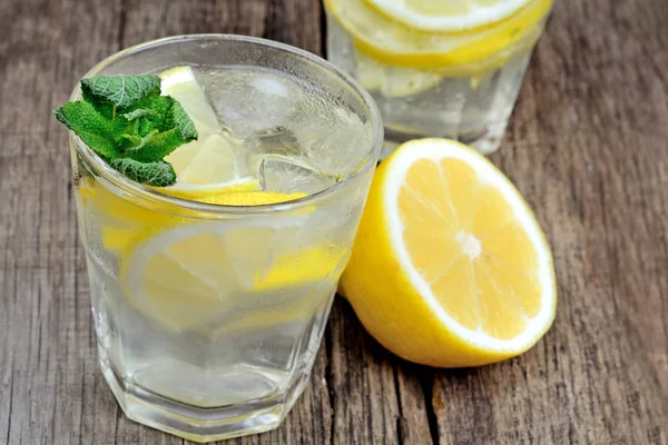 Detox water with fresh lemon and mint on table