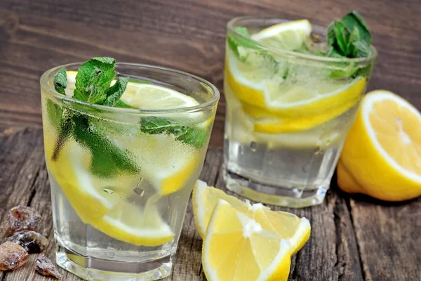 Wasser mit frischer Zitrone und Minze auf Holz-Hintergrund — Stockfoto