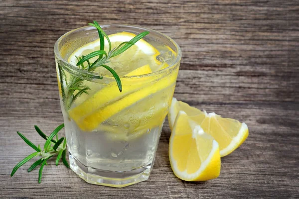 Leckeres Getränk mit Zitrone und Rosmarin auf Holztisch — Stockfoto
