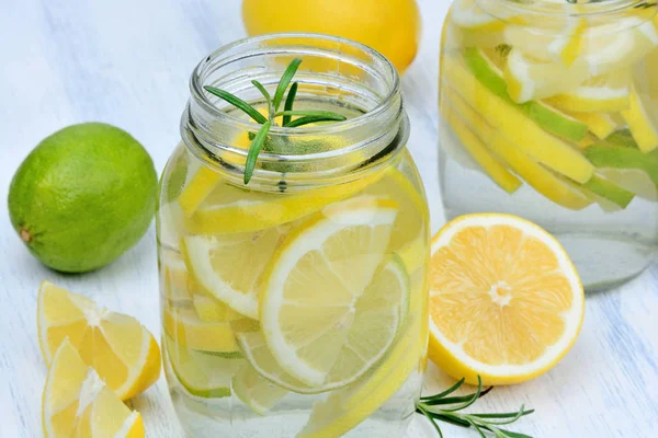 Detox water with lemon and rosemary in a jars on table — Stock Photo, Image