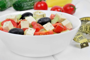 Tabakta sebze salatası ve santimetre.