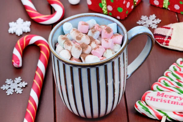 Heiße Schokolade im Becher mit buntem Marshmallow auf einem Holztisch — Stockfoto