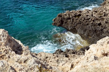 Kıbrıs adası yakınlarındaki masmavi deniz, Akdeniz kıyısı. Deniz kıyısında köpüklü dalgalar
