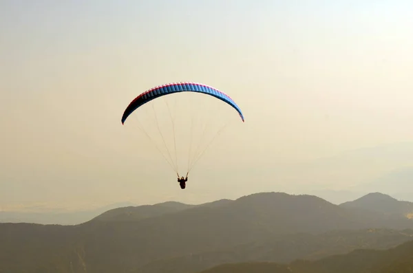 Gökyüzünde, dağların ve denizin üzerinde uçuşan paraşütler. Türkiye 'nin Tahtali Dağı' ndan görüntü. Olağanüstü bir spor. Peyzaj