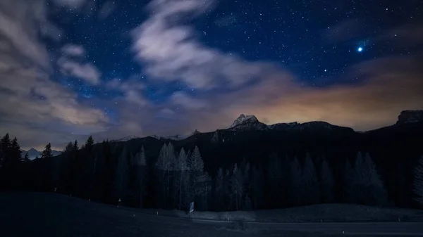 Cielo nocturno estrellas y nubes sobre montañas Imagen De Stock