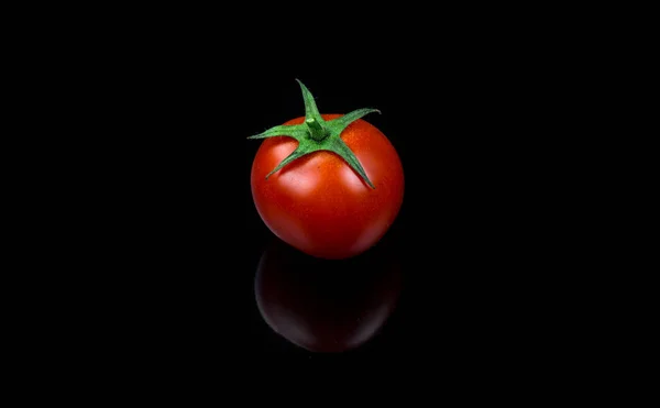 Čerstvých cherry rajčátek singl na černém pozadí Royalty Free Stock Obrázky
