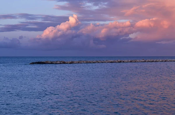 Impresionante puesta de sol sobre el mar y las rocas. Costa frente al mar de Bari. Blu. — Foto de Stock