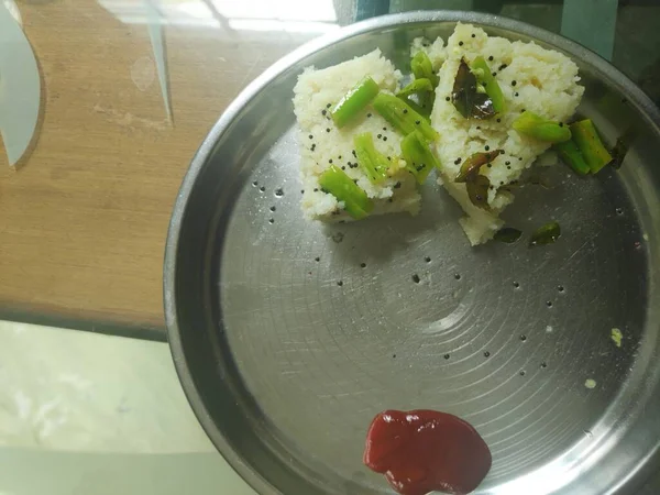 ドクラ Dhokla グジャラート州に起源を持つ米粉を使ったインドのセイボリー スナックである 鋼板に盛り付け — ストック写真