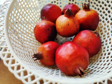 Beyaz sepetteki nar meyveleri.