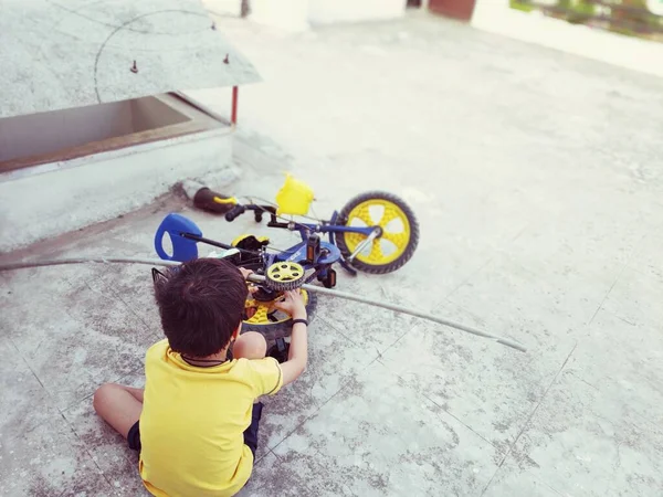 Счастливый Маленький Мальчик Чинит Свой Велосипед Крыше Дома — стоковое фото