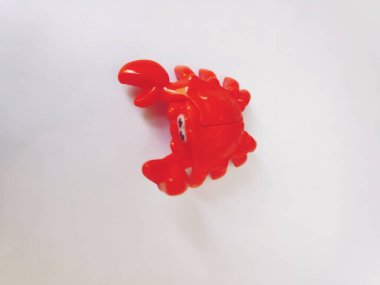 Beyaz arkaplanda kırmızı plastik yengeç izole edildi.