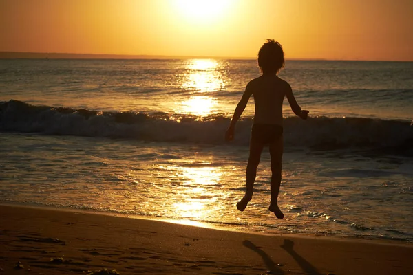 해질녘 해변에서 재생 하는 소년 — 스톡 사진