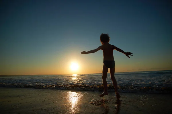 夕暮れ時のビーチで遊ぶ少年 — ストック写真