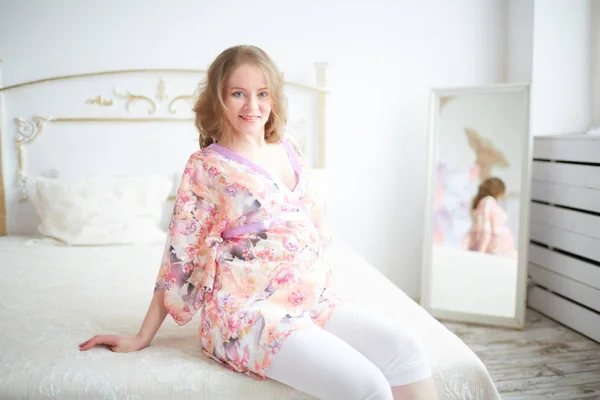 Беременная женщина в спальне — стоковое фото