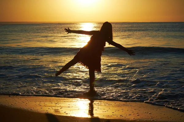 Girl playing on beach at sunset — Stock Photo, Image