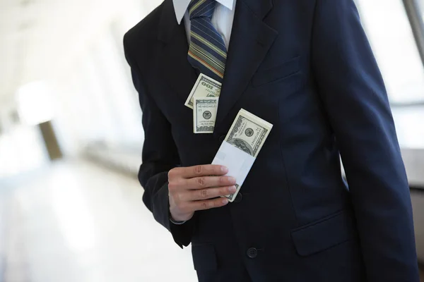 Деньги в кармане бизнесмена — стоковое фото
