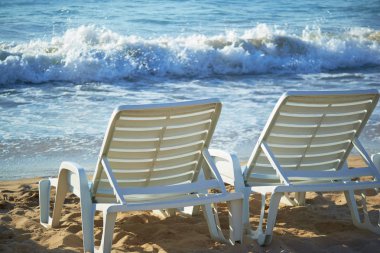 gündoğumu iki şezlong ile sahilde