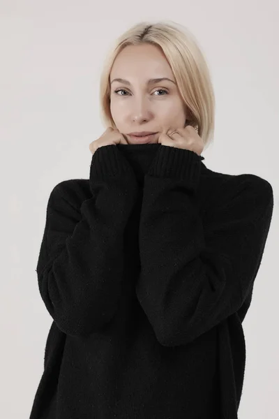 Blonde in een zwarte trui — Stockfoto