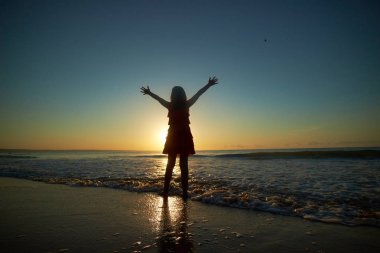 Kumsalda oynayan kız.